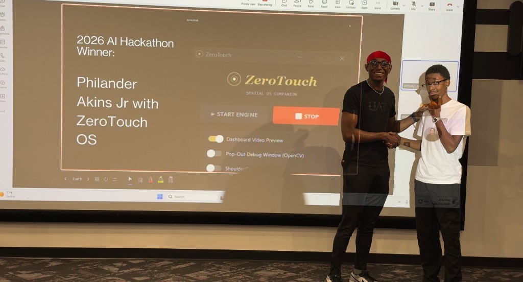 Philander Akins Jr shaking hands with UAT AI Club President on stage celebrating 1st Place win at the 2026 AI Hackathon for ZeroTouch OS